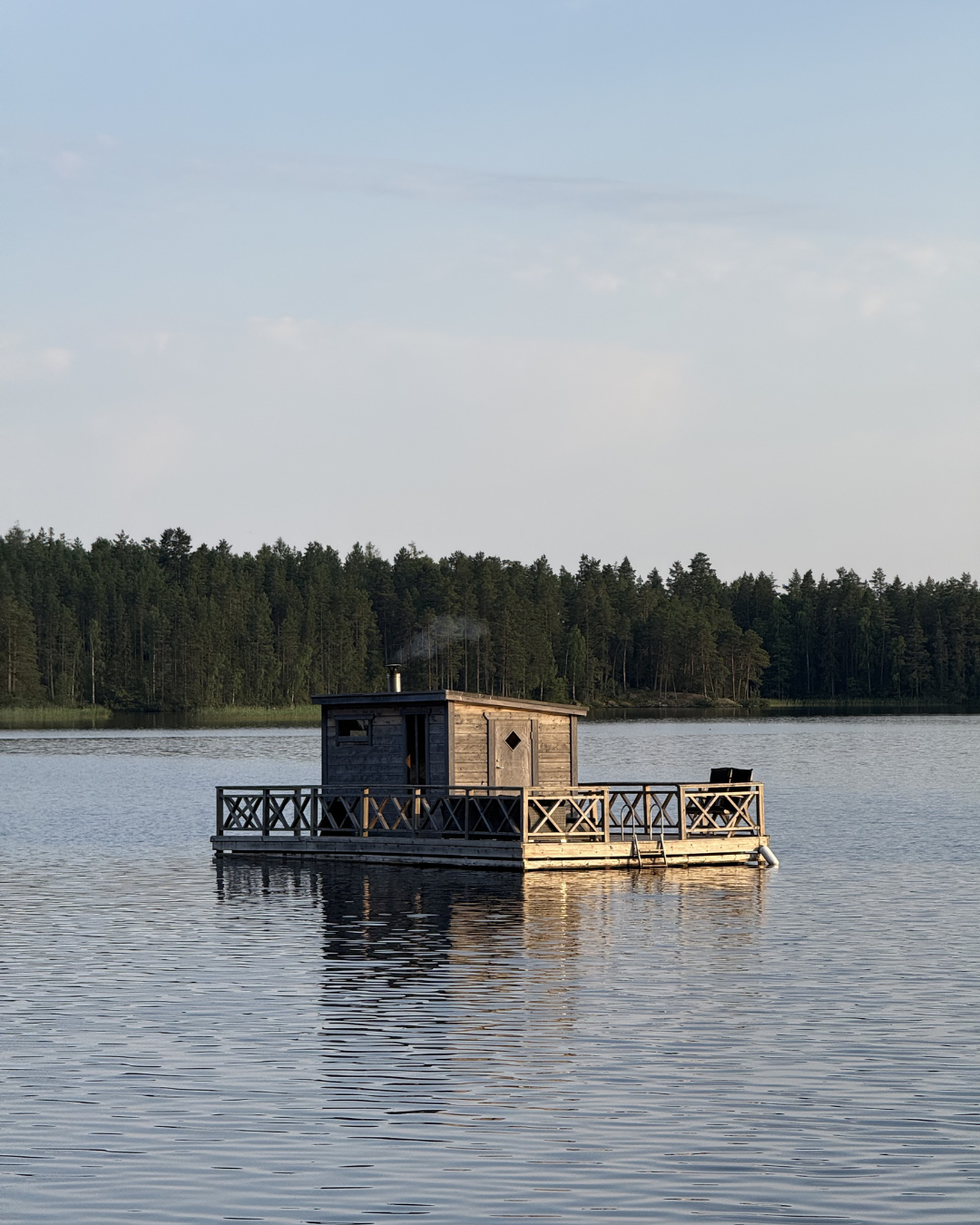 Floating sauna on a Swedish lake surrounded by nature.